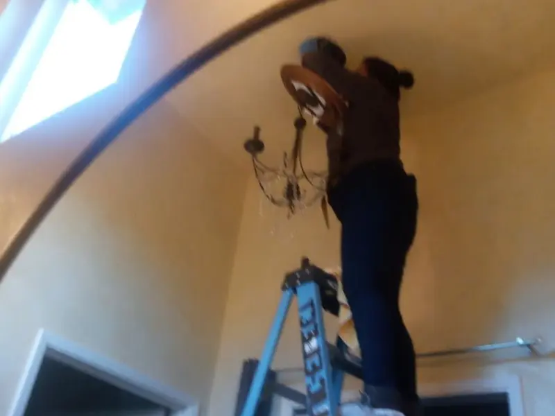 Electrician installing a chandelier in a Kent residence